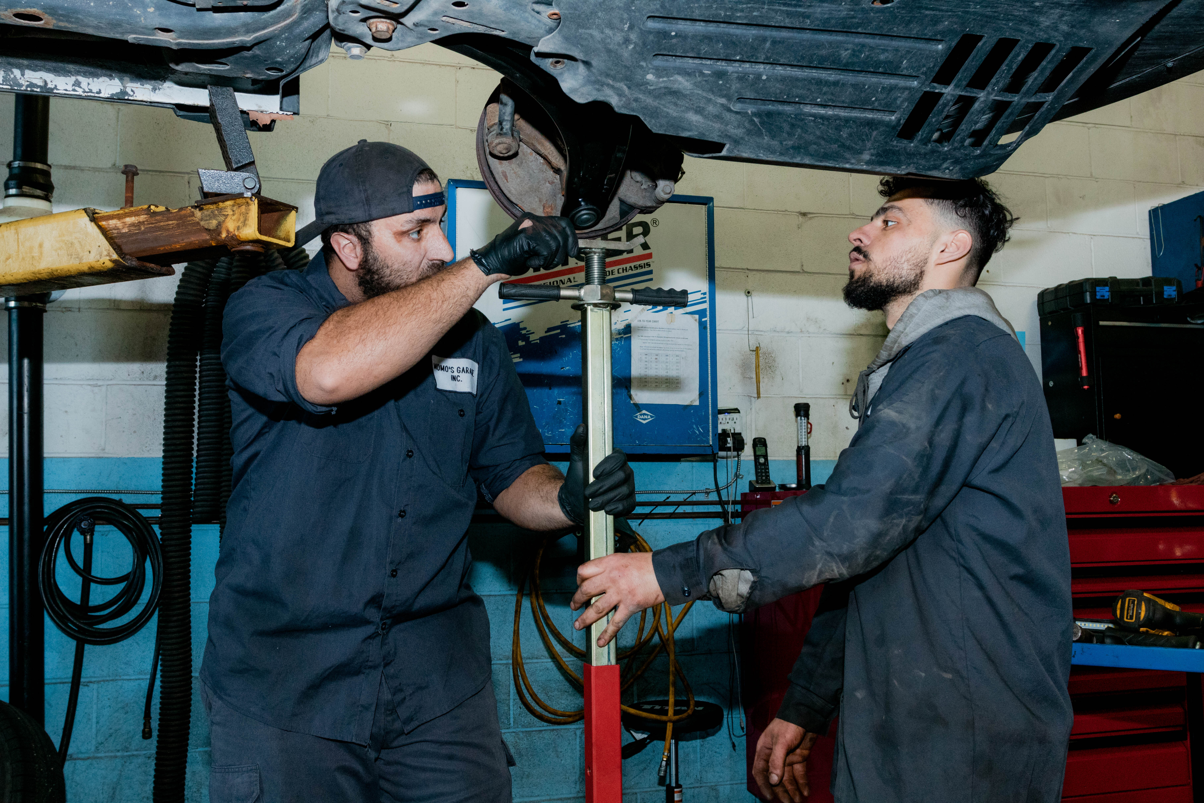 Mechanics working under a vehicle