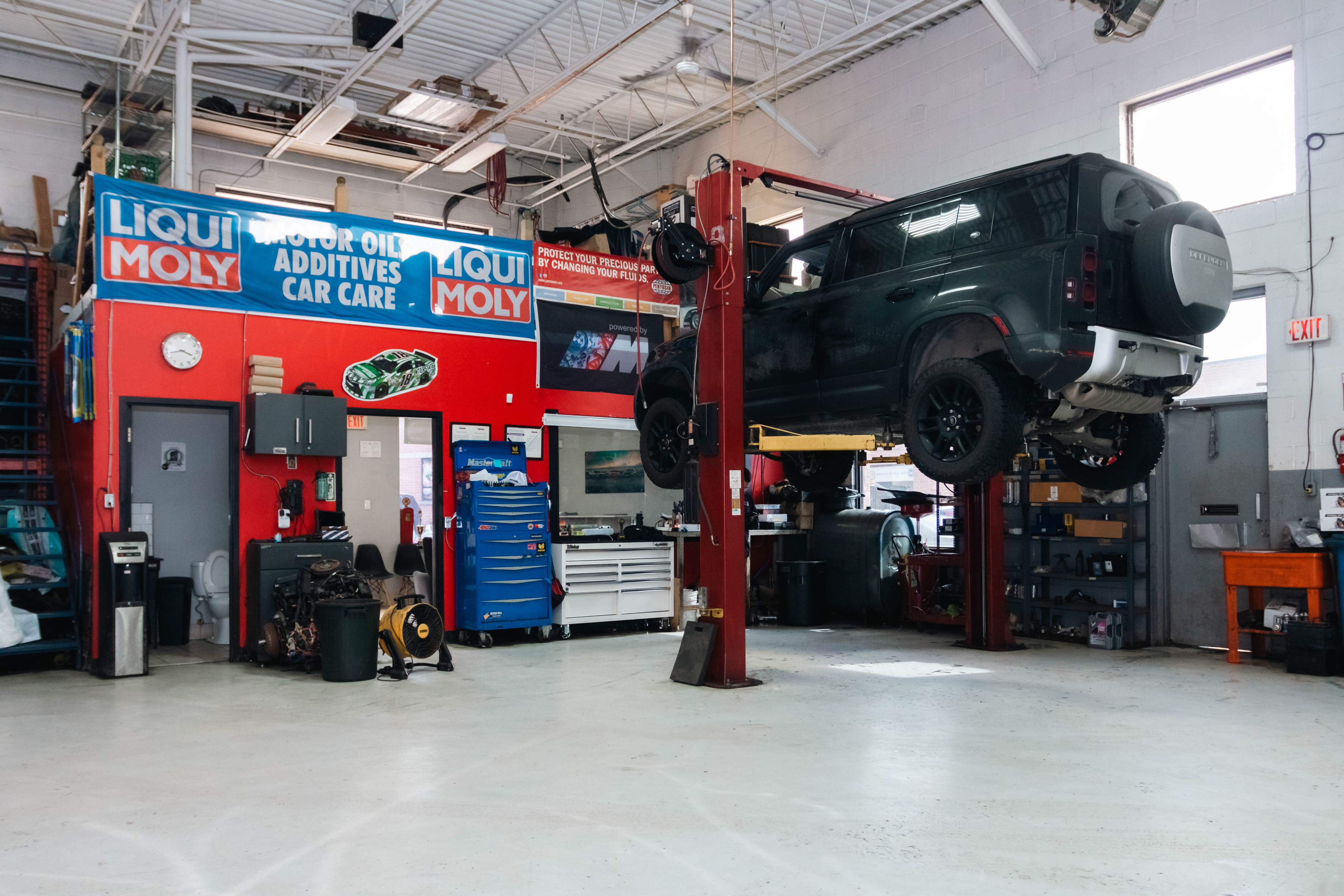 Performance shop with a car on a lift surrounded by products