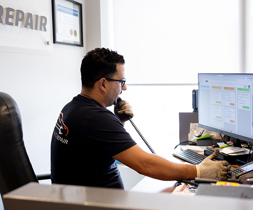 A mechanic shaking hands with a customer in a workshop after agreeing on a job estimate