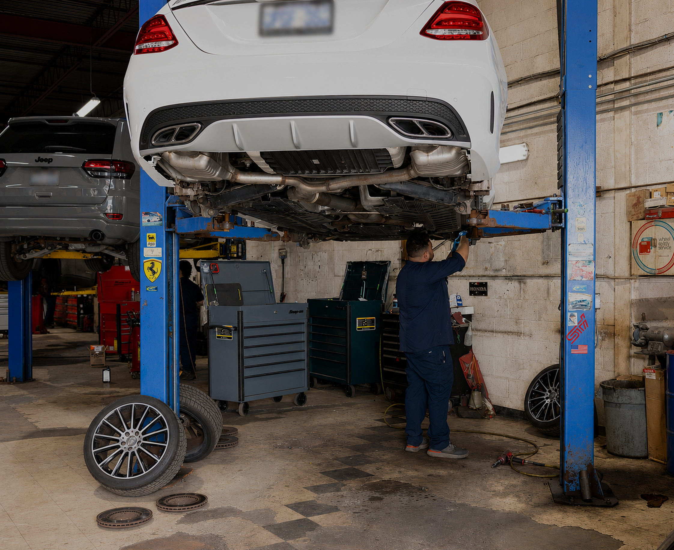 Mechanic working under a lifted vehicle in a workshop