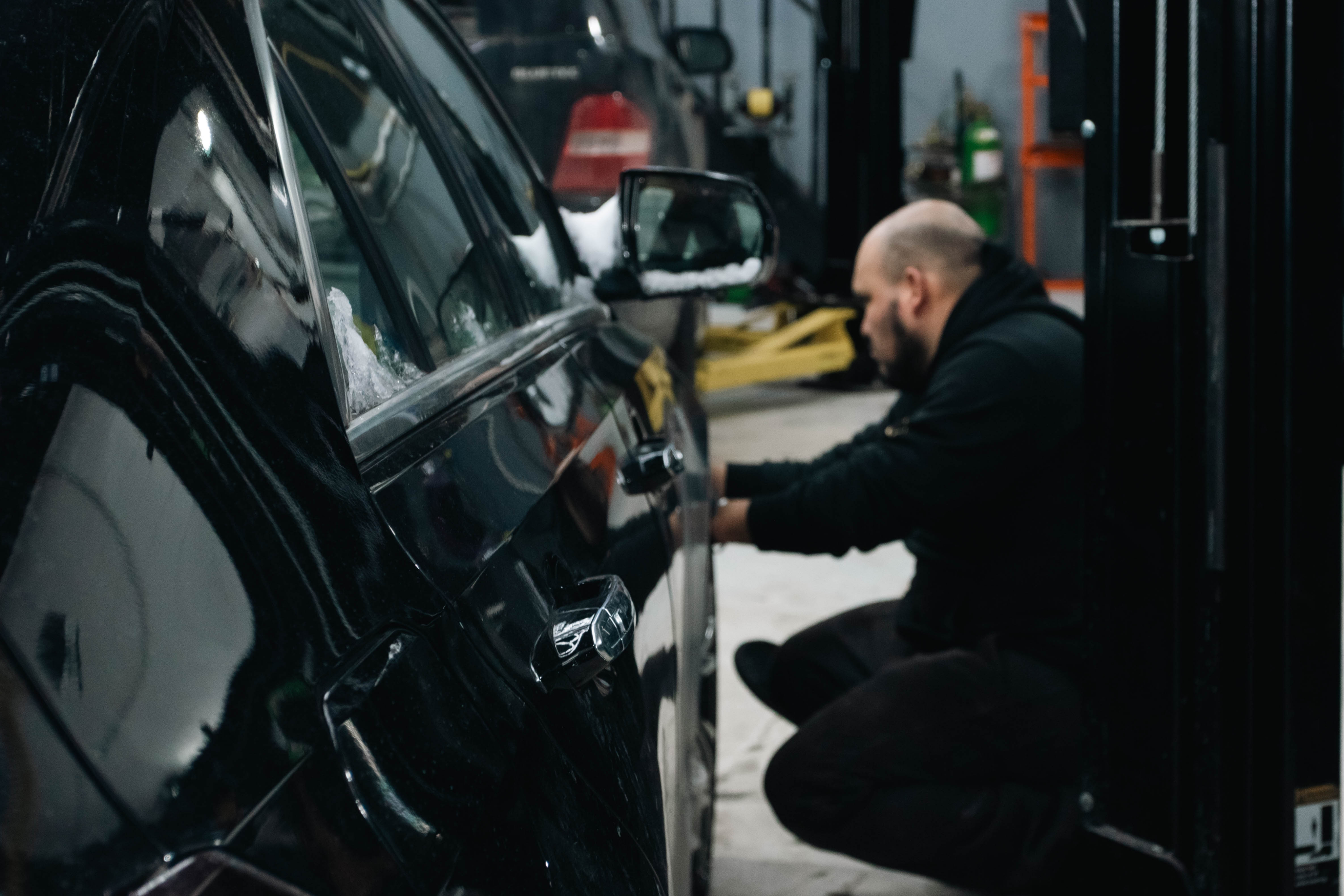 Mechanic working underneath a vehicle on a lift